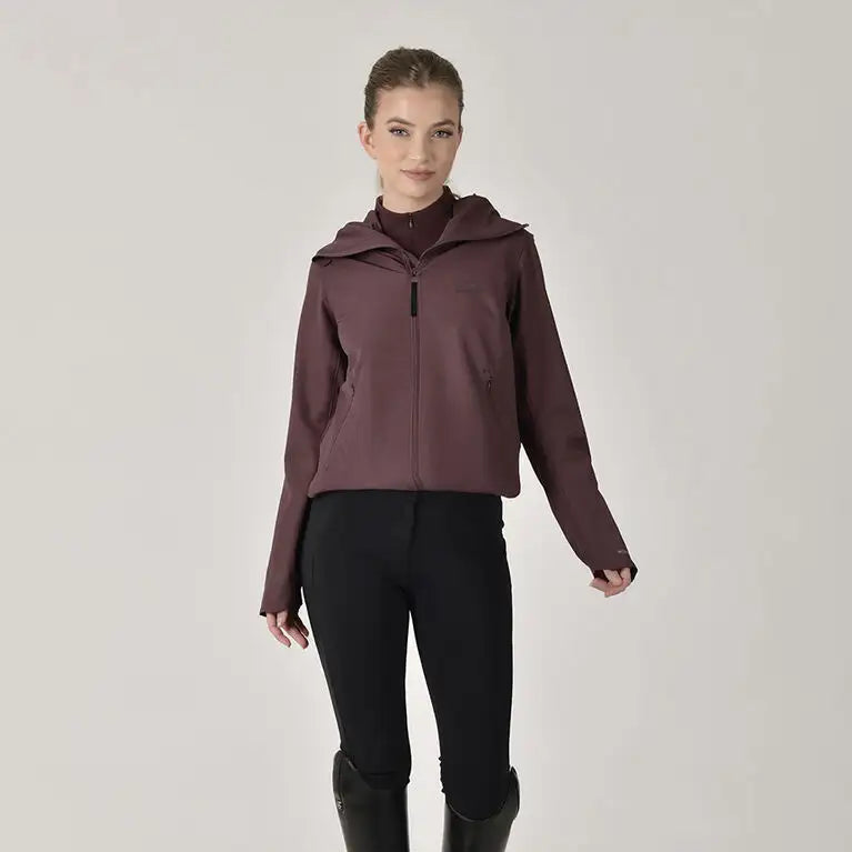 Woman wearing a maroon jacket, black pants, and black boots on a white background