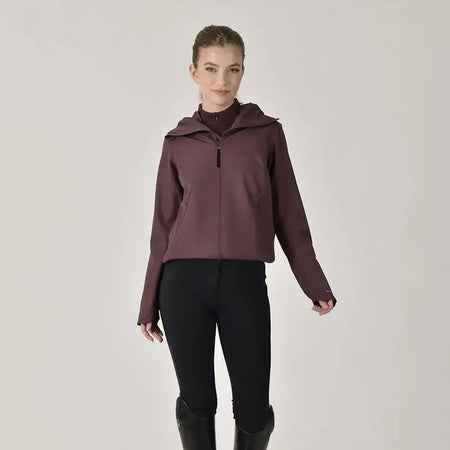 Woman wearing a maroon jacket, black pants, and black boots on a white background