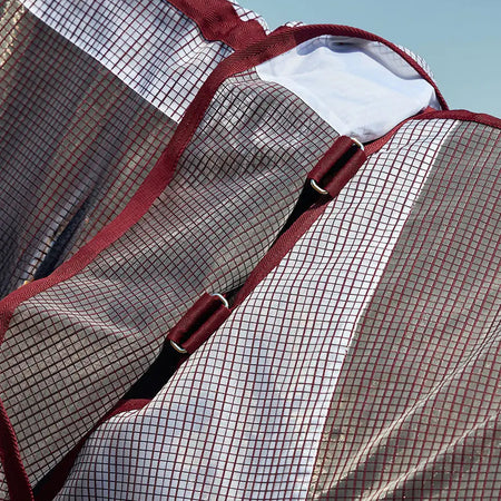 Close-up of a mesh bag with red trim against a blue sky.