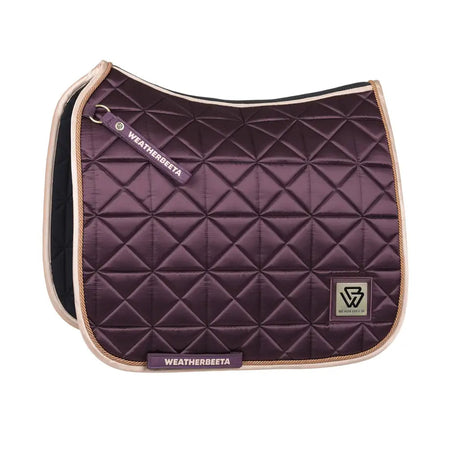 Purple quilted saddle pad with beige border and Weatherbeeta logo on a white background