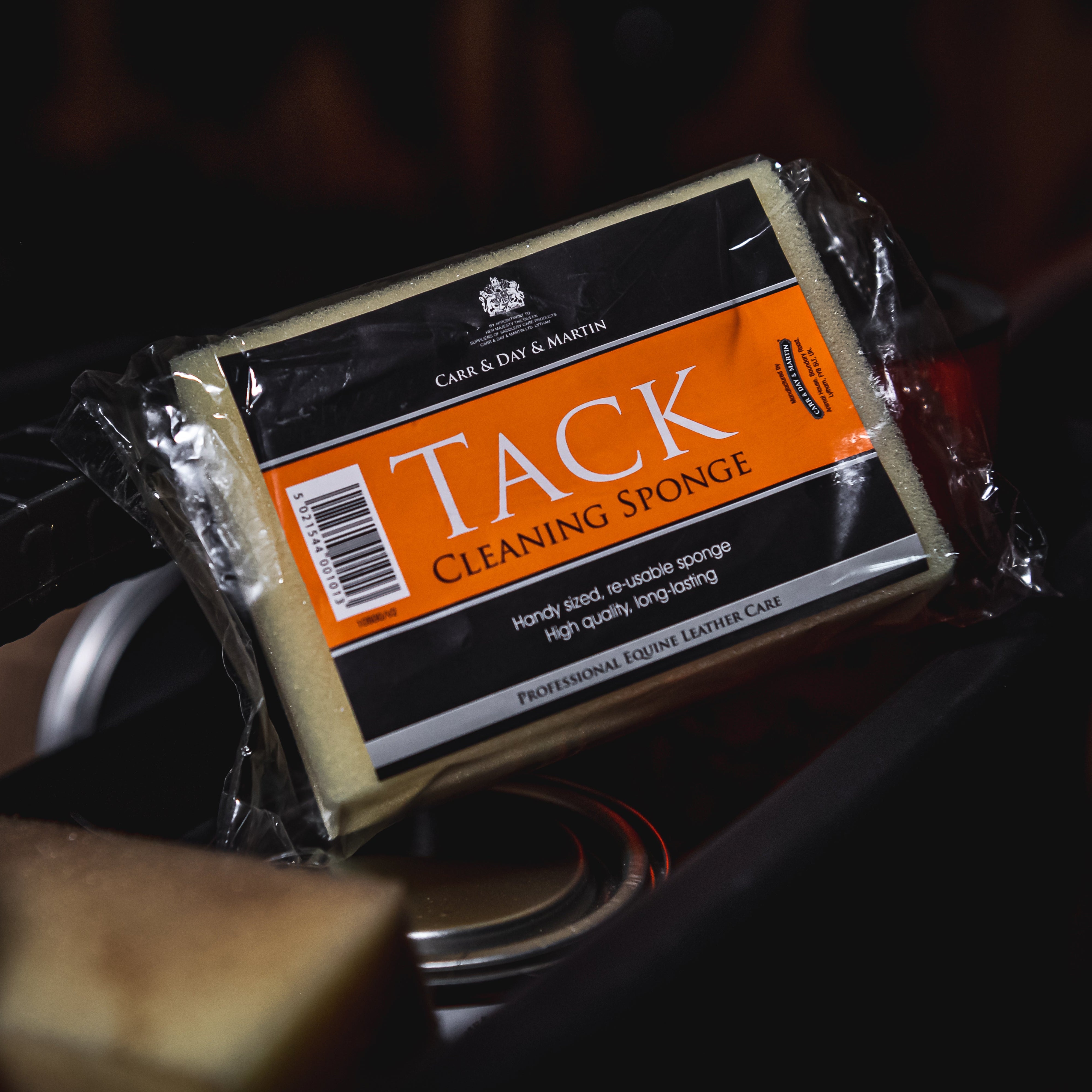 Tack cleaning sponge packaging with visible brand name on a dark background